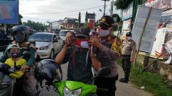 Kapolsek Tanjungpinang Timur Polres Tanjungpinang, AKP Firuddin saat memasangkan masker ke pengendara yang melintas di kilometer 10, Tanjungpinang, Sabtu (10/8/2020).