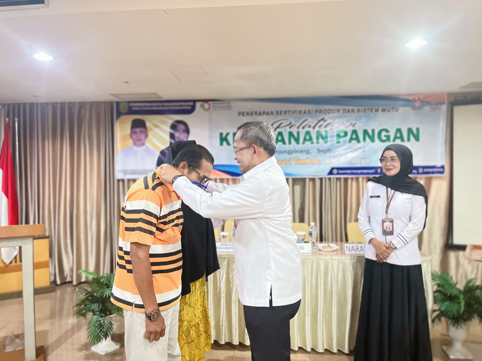 Asisten 2 Bidang Ekonomi Pembangunan Kota Tanjungpinang, Bambang Hartanto saat menyematkan tanda peserta pembukaan pelatihan penyuluhan keamanan pangan, Disperdagin Tanjungpinang, di Plaza Hotel, Selasa (28/9/2022)
