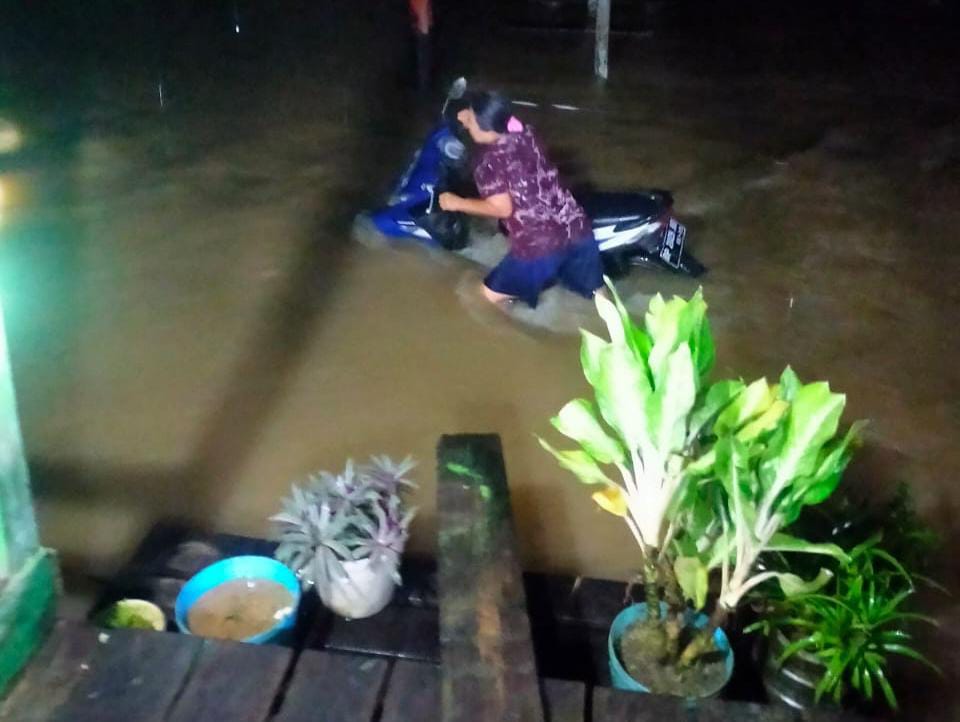 Warga saat menyelamatkan kendaraan roda dua yang terendam banjir di Desa Sebadai Ulu, Kecamatan Bunguran Timur Laut. (Foto : Istimewa)