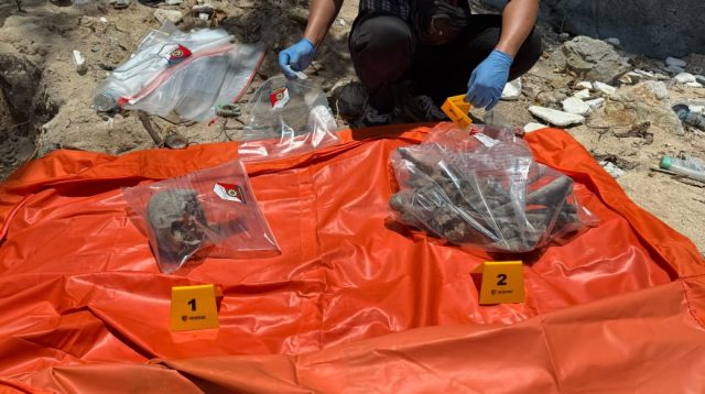 Petugas Sat Reskrim Polres Kepulauan Anambas bersama tim medis memasang garis polisi dan mengamankan barang bukti tulang belulang yang ditemukan di Pulau Noran, Desa Batu Ampar. (Foto: Dokumentasi Polres Anambas)