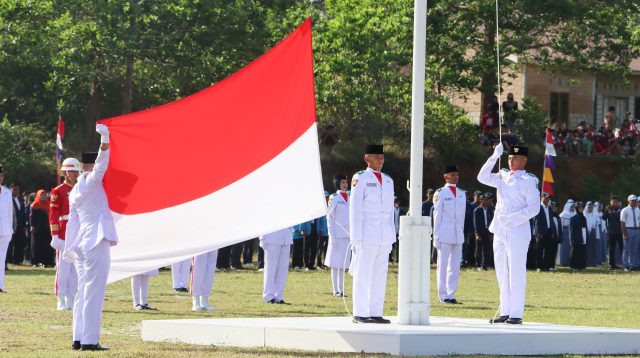 Pengibaran sangsaka merah putih dalam upacara HUT ke-80 RI di Lapangan Bukit Kerang, Kecamatan Gunung Kijang, disaksikan ribuan warga yang memadati area upacara, Minggu (17/8/2025)