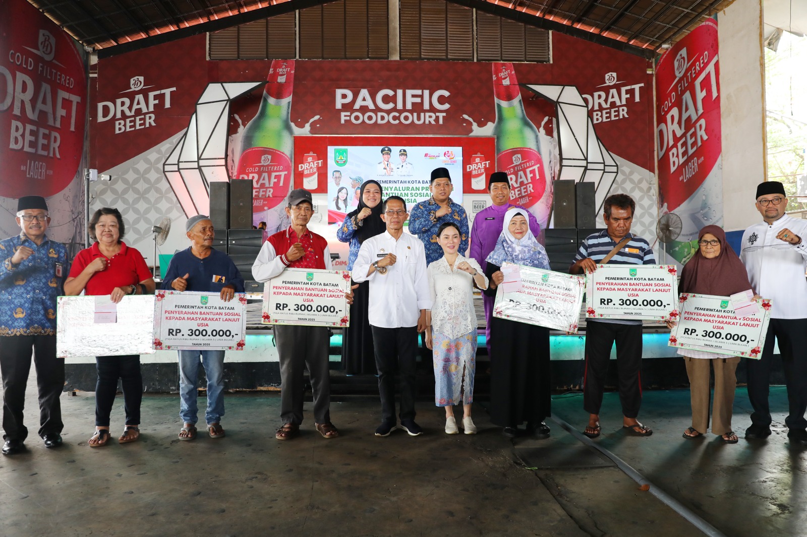 Wali Kota Batam, Amsakar Achmad, bersama Wakil Wali Kota Batam, Li Claudia Chandra, saat menyerahkan bantuan sosial bagi warga lanjut usia di Food Court Hotel Pacific, Jumat (17/10/2025).