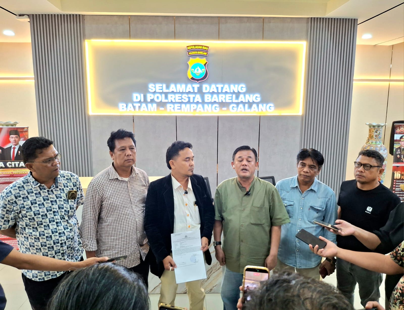 Usai melapor ke Polresta Barelang, Lintong Carles Manurung menyampaikan keterangan kepada media didampingi tim penasihat hukum dan rekan-rekan wartawan, Kamis (11/6/2026). Laporan itu terkait dugaan pencemaran nama baik setelah fotonya dipajang dengan label "Blacklist" di area publik sebuah tempat hiburan malam di Batam. (Foto: PWI Kepri)