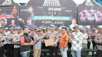 Ketua PWI Kepri Saibansah Dardani menyerahkan karikatur foto Kombes Eddwi Kurniyanto di hadapan personel Bidpropam Polda Kepri di pelataran GOR 93 Milang, Batam, Rabu (9/9/2026). (Foto: PWI Kepri)
